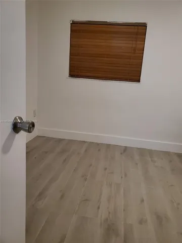 a view of room with wooden floor and flat screen tv
