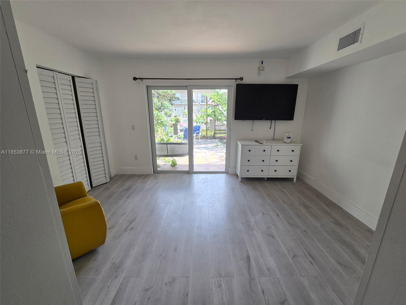 6886 Northwest 166th Terrace, Unit 1004 Miami Lakes, FL 33014 - Photo 8 of 27 a view of room with wooden floor and flat screen tv