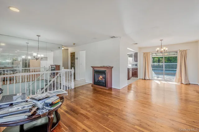 a view of kitchen with stainless steel appliances granite countertop a stove top oven a refrigerator a dining table and chairs with wooden floor