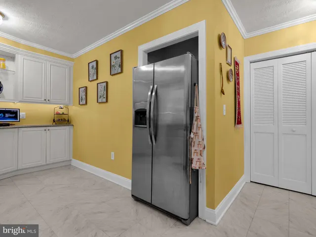 a view of a kitchen with a refrigerator and an entryway