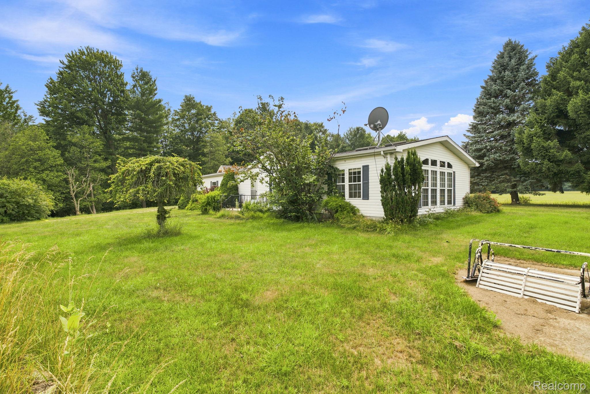 2390 Lakeshore Road Applegate, MI 48401 - Photo 95 of 97 Expansive grounds featuring a manicured lawn, mature tree-lined perimeter, and a single-story residence with contemporary architectural styling