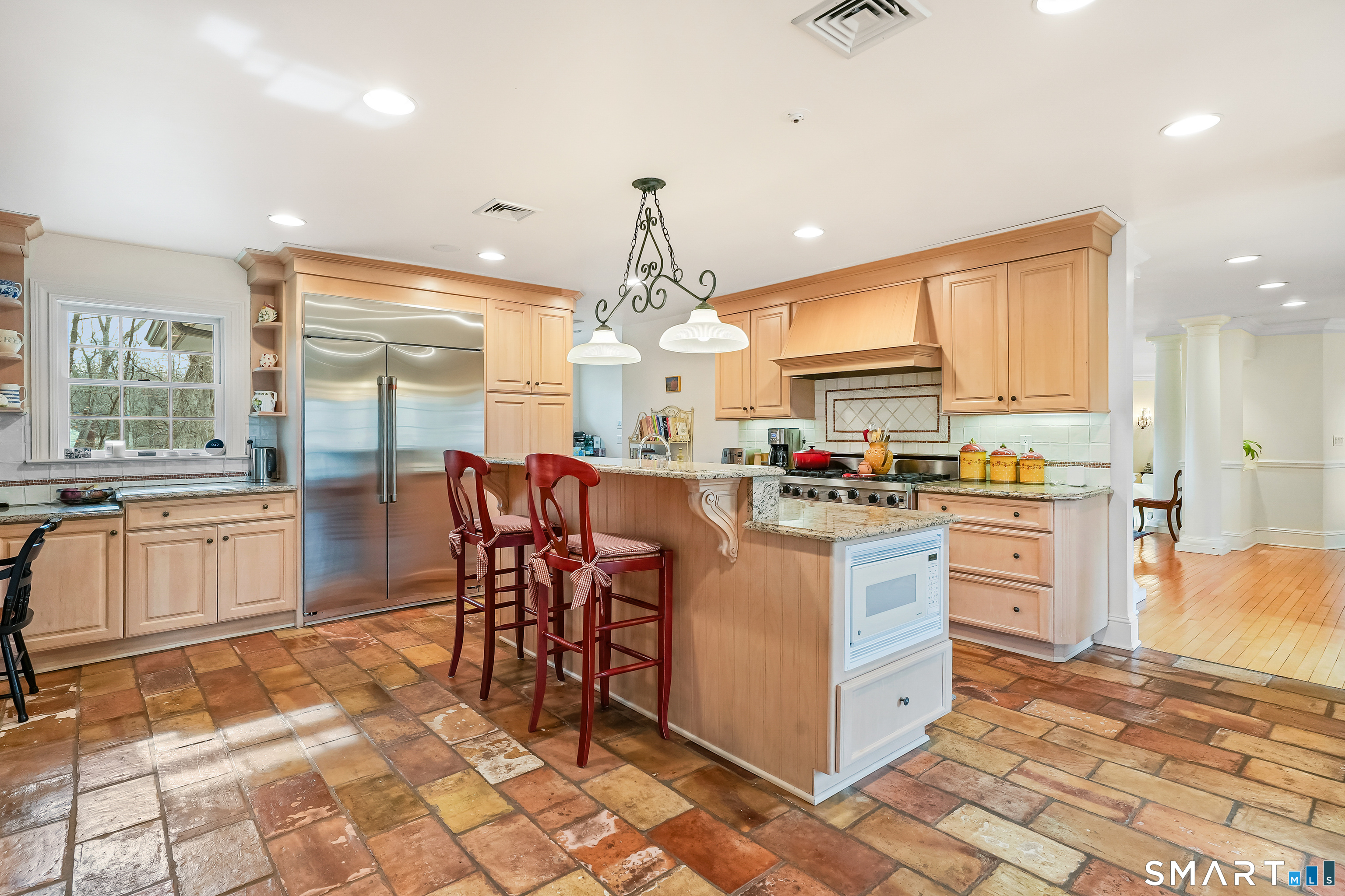 41 Lake Wind Road New Canaan, CT 06840 - Photo 7 of 38 a kitchen with stainless steel appliances granite countertop a stove top oven a sink a dining table and chairs