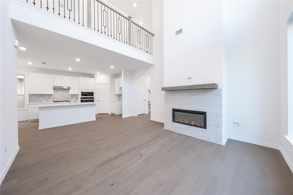 1413 Sun Gdn Way Justin, TX 76247 - Photo 12 of 36 a view of kitchen with kitchen island wooden floor and a fireplace