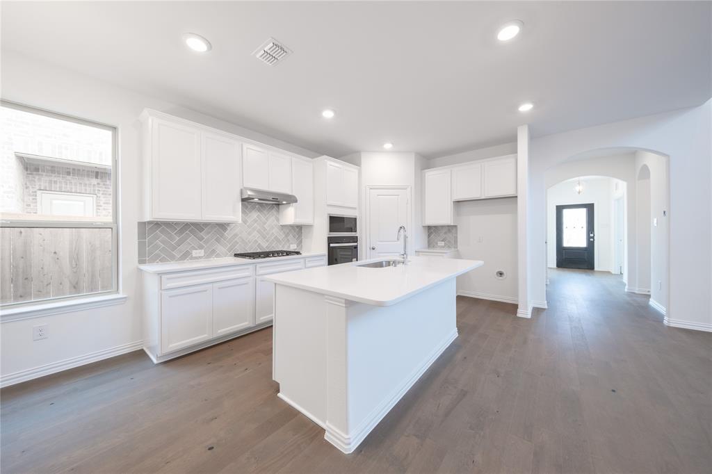 1413 Sun Gdn Way Justin, TX 76247 - Photo 4 of 36 a kitchen with white cabinets and sink