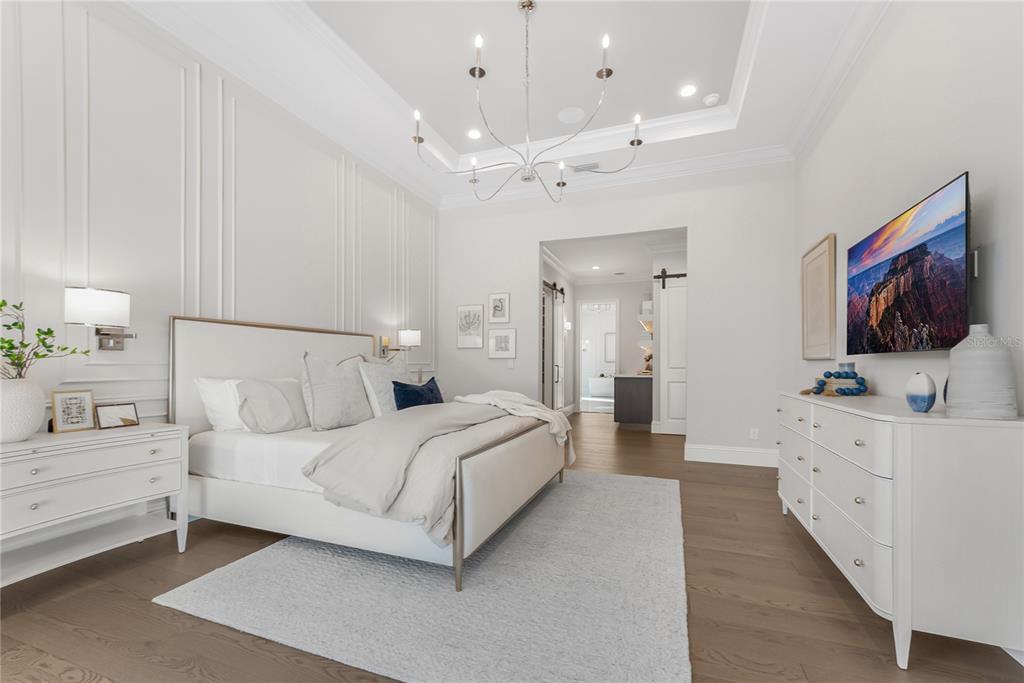 1621 Rio Vista Terrace Parrish, FL 34219 - Photo 13 of 27 a bedroom with a bed mirror on dresser and a flat screen tv