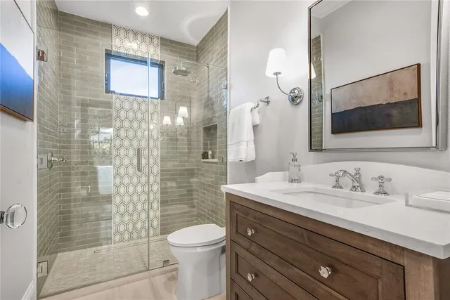 a bathroom with a sink a toilet and shower