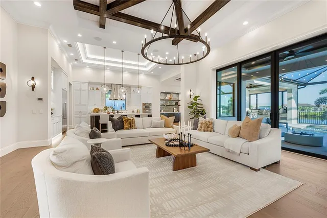 a living room with furniture a large window and stainless steel appliances