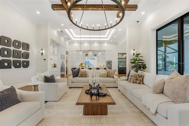 a living room with furniture a chandelier and a large window