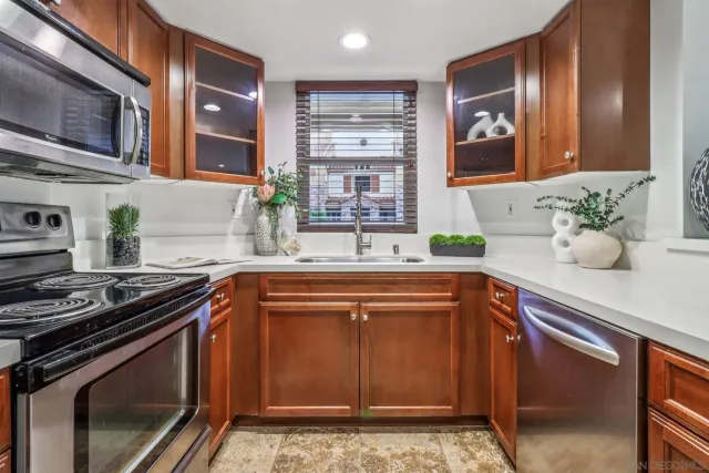 a kitchen with stainless steel appliances granite countertop a sink stove and cabinets