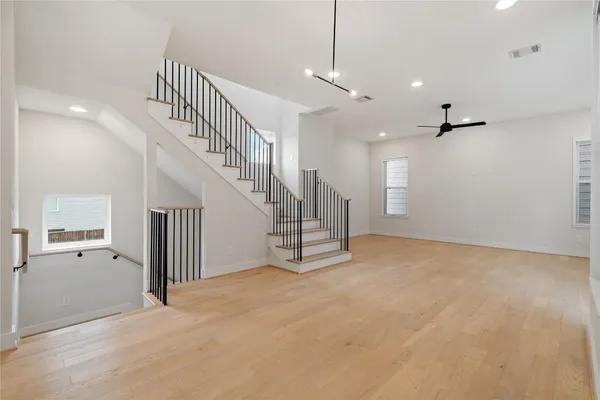 a view of an empty room with stairs and windows