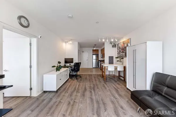 a room with stainless steel appliances a refrigerator and wooden floor