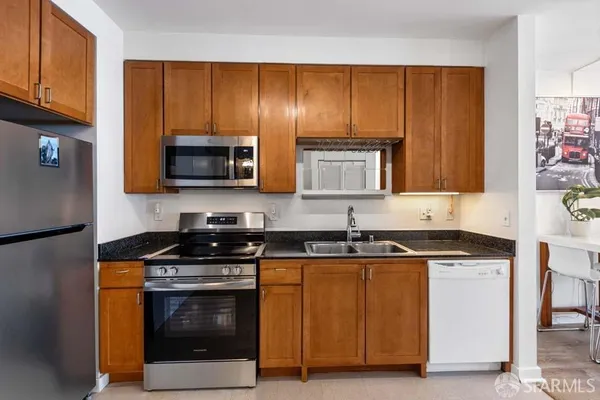 a kitchen with granite countertop wooden cabinets and a stove top oven
