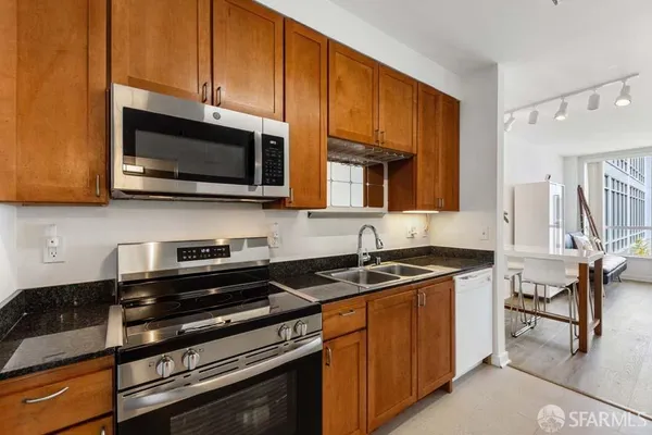 a kitchen with stainless steel appliances granite countertop a stove microwave and cabinets