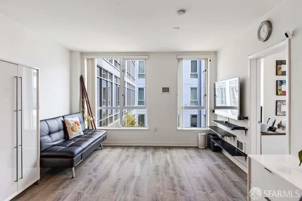 a living room with furniture and a wooden floor