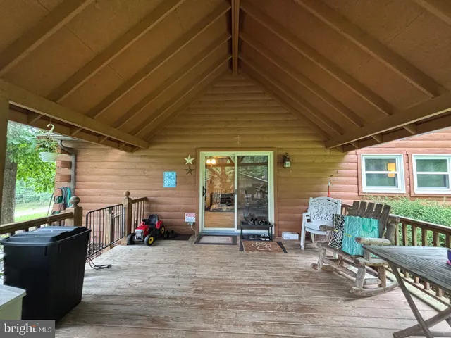 a view of a patio with lawn chairs floor to ceiling window wooden floor and fence