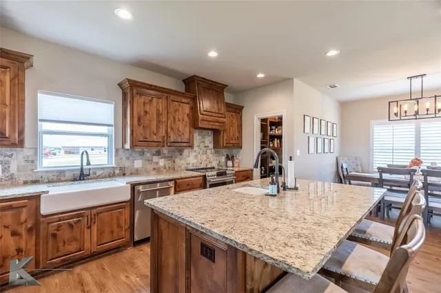a kitchen with stainless steel appliances granite countertop a sink stove and cabinets