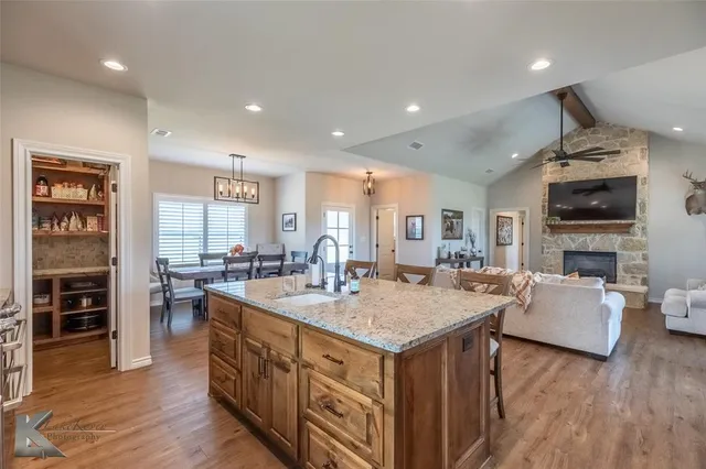 a large kitchen with kitchen island a sink table and chairs