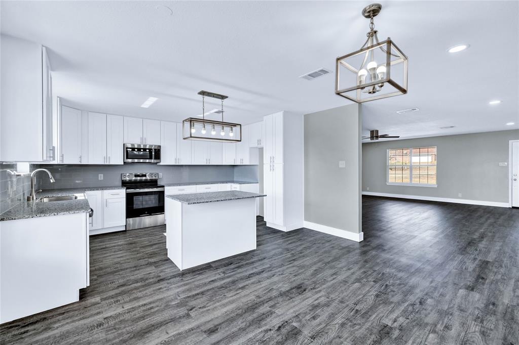 566 McCraw Lane Denison, TX 75021 - Photo 11 of 25 a kitchen with stainless steel appliances granite countertop a sink a stove a refrigerator cabinets and wooden floor