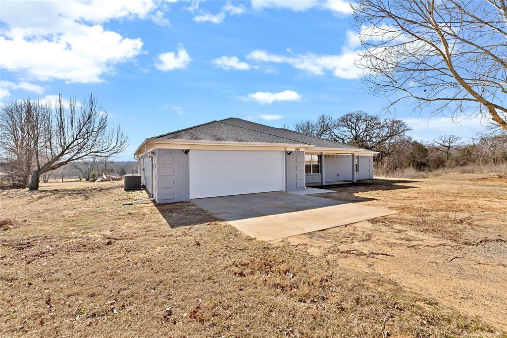 566 McCraw Lane Denison, TX 75021 - Photo 2 of 25 a front view of a house with a yard and garage