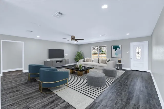 a living room with furniture wooden floor and a flat screen tv