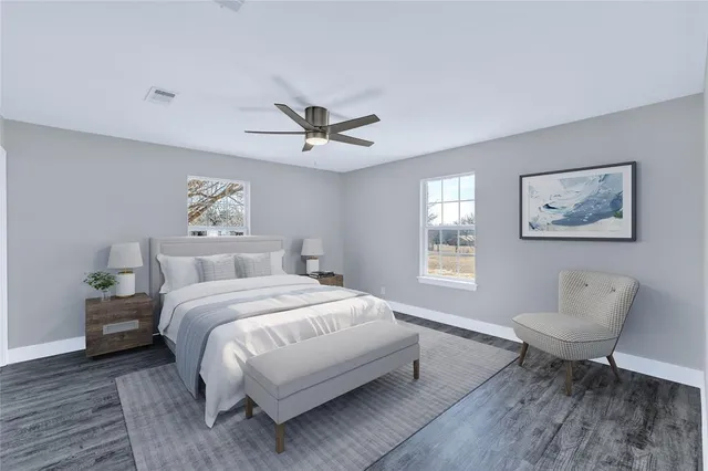 a spacious bedroom with a bed and a painting on the wall