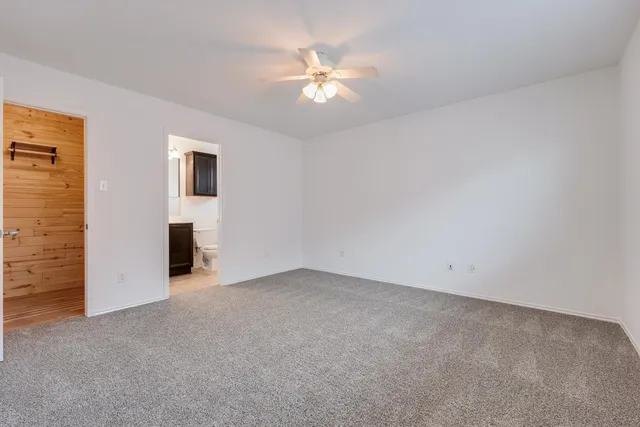 a view of an empty room with a ceiling fan and a window