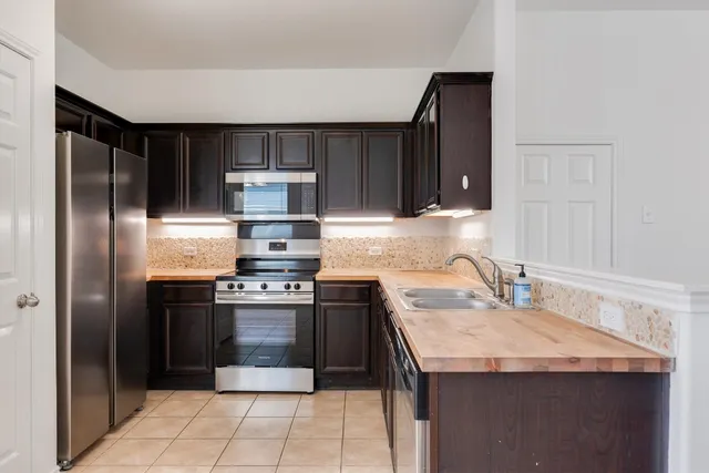 a kitchen with kitchen island granite countertop a sink stove and refrigerator