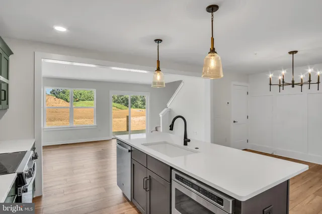 a kitchen with a sink a stove and a wooden floor
