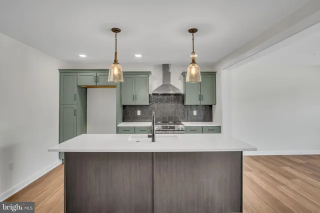 a view of a kitchen with a sink refrigerator and wooden floor