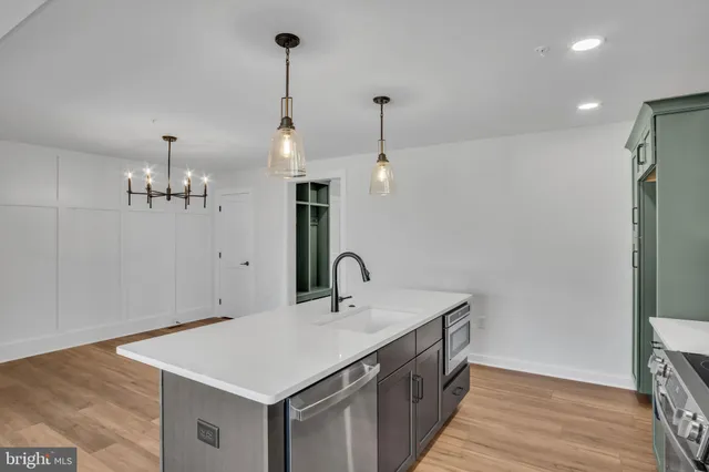 a kitchen with a sink a counter space and wooden floor