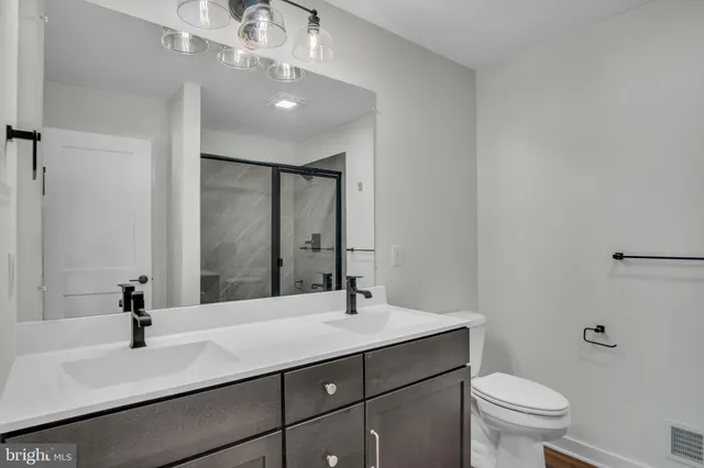 a bathroom with a sink a toilet and a mirror