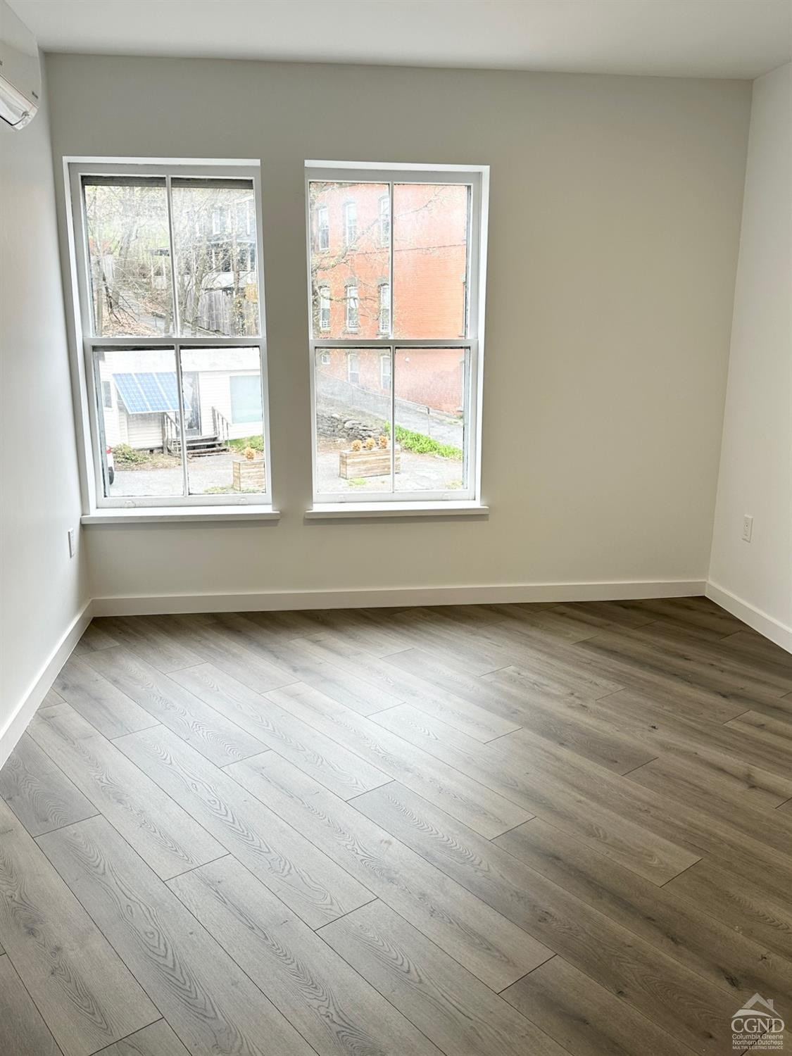 473 Main Street, Unit 1 Catskill, NY 12414 - Photo 4 of 11 an empty room with wooden floor and windows