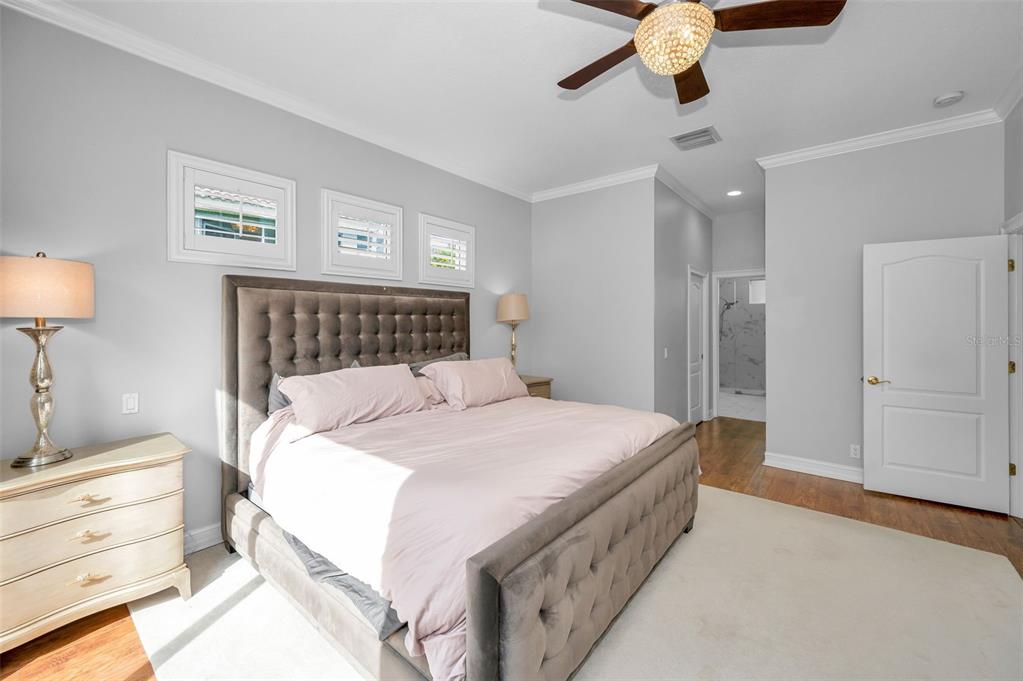 9952 Sago Point Drive Largo, FL 33777 - Photo 20 of 44 a bedroom with a bed and a chandelier