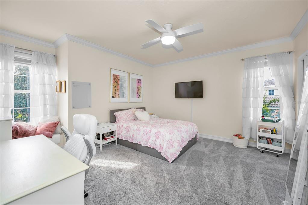 9952 Sago Point Drive Largo, FL 33777 - Photo 24 of 44 a spacious bedroom with a bed and a chandelier