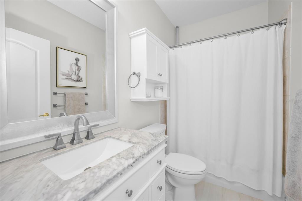 9952 Sago Point Drive Largo, FL 33777 - Photo 25 of 44 a bathroom with a granite countertop sink mirror vanity and toilet