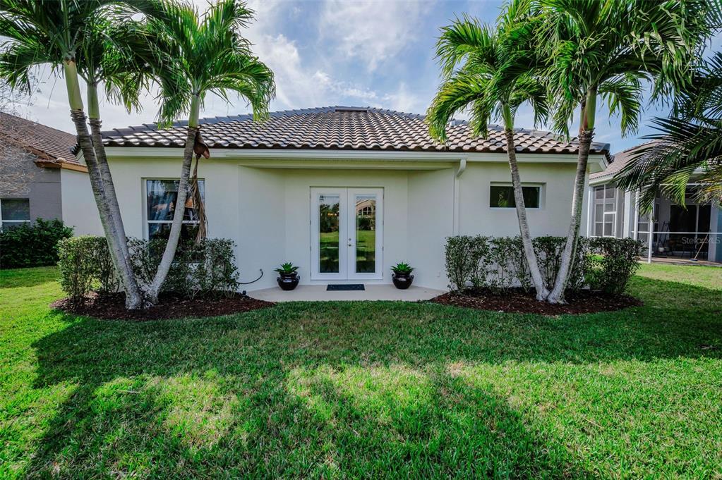 9952 Sago Point Drive Largo, FL 33777 - Photo 35 of 44 a view of a house with a yard potted plants and a palm tree