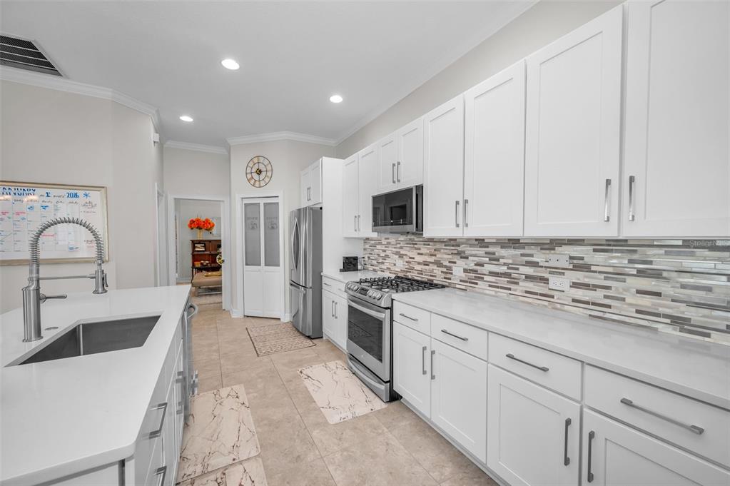 9952 Sago Point Drive Largo, FL 33777 - Photo 6 of 44 a kitchen with granite countertop a sink stainless steel appliances and white cabinets