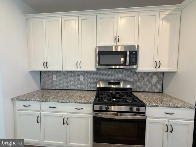 a kitchen with kitchen island granite countertop wooden cabinets and a granite counter tops