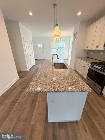 a kitchen with kitchen island granite countertop a sink a counter space and a window