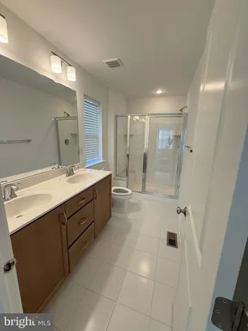 a spacious bathroom with a shower sink mirror and
