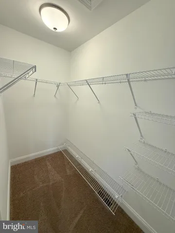 an empty room with windows and ceiling fan