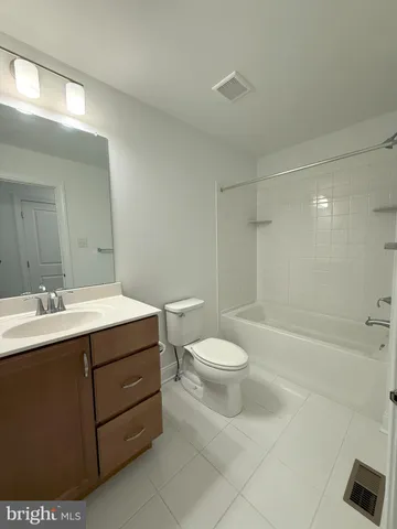 a white toilet and tub sitting next to a bathroom sink