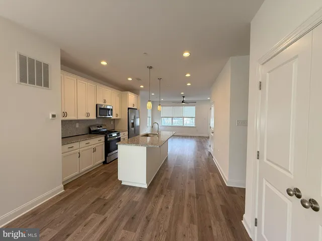 a kitchen with granite countertop a refrigerator and a stove