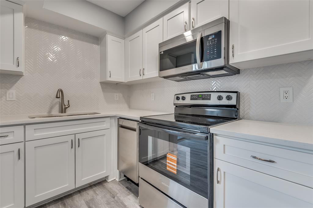 5033 Cedar Springs Road, Unit 103 Dallas, TX 75235 - Photo 2 of 12 a kitchen with white cabinets stainless steel appliances and sink