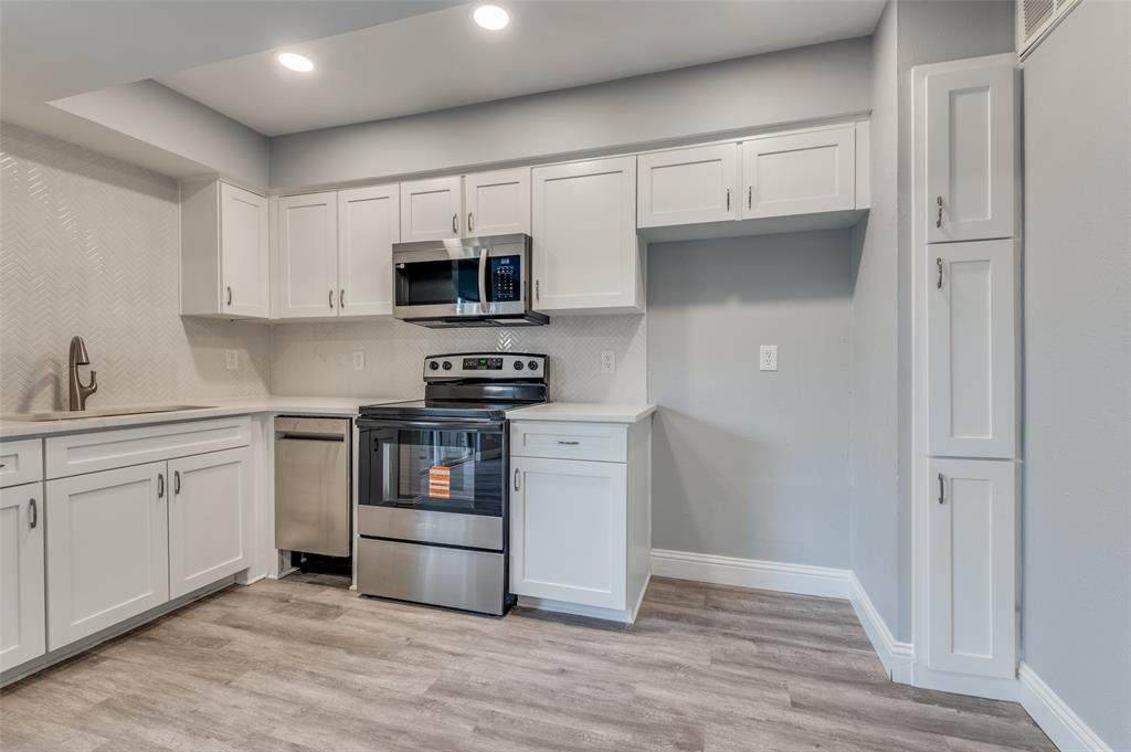 5033 Cedar Springs Road, Unit 103 Dallas, TX 75235 - Photo 3 of 12 a kitchen with stainless steel appliances a stove a microwave and white cabinets