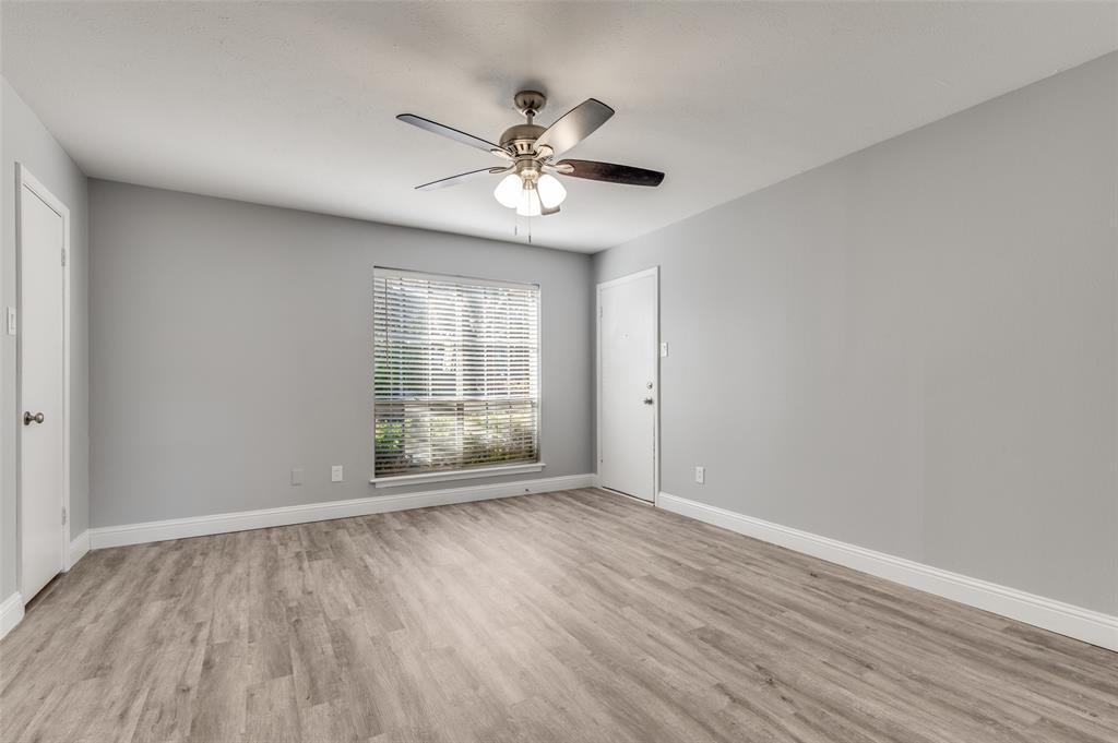 5033 Cedar Springs Road, Unit 103 Dallas, TX 75235 - Photo 6 of 12 a view of an empty room with wooden floor and a window