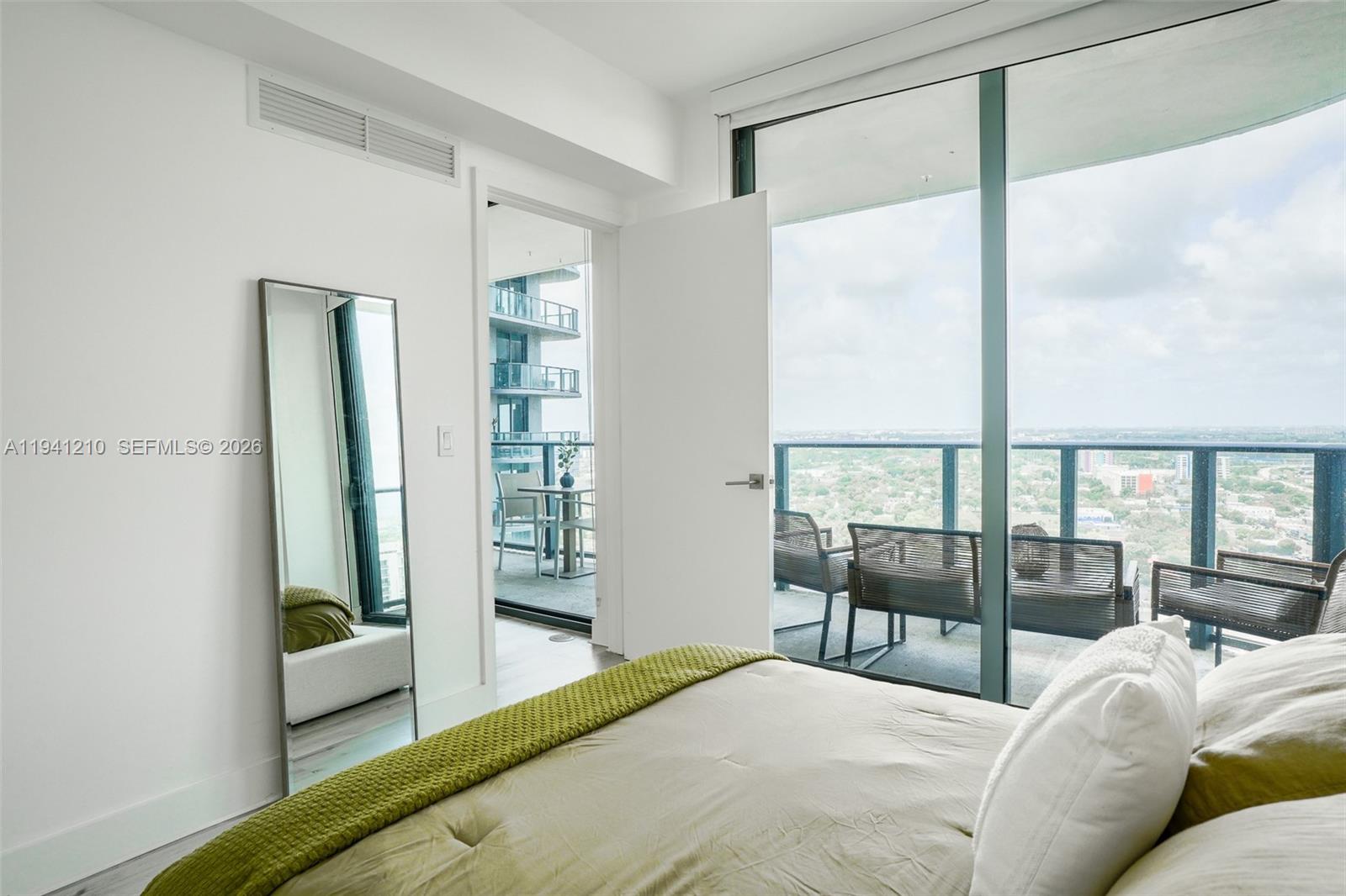 121 Northeast 34th Street, Unit 2711 Miami, FL 33137 - Photo 9 of 42 a bedroom with a large bed and a balcony view