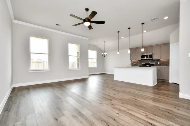 a view of a kitchen with a stove wooden floor and a ceiling fan