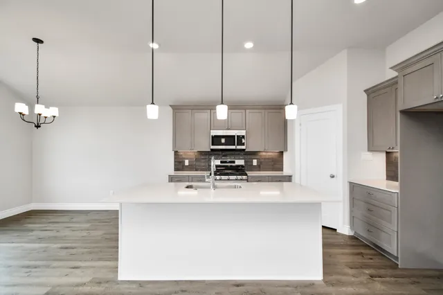 a kitchen with stainless steel appliances kitchen island a refrigerator and a view of living room