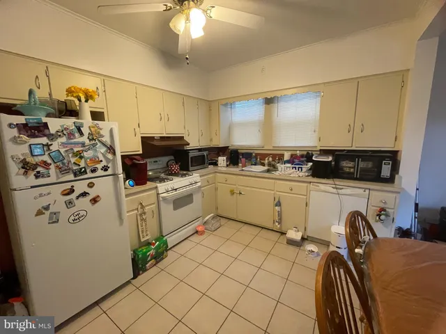 a kitchen with stainless steel appliances a stove a sink and white cabinets